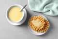 Flat lay composition with bowl of condensed milk and waffles on grey Royalty Free Stock Photo