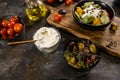 Flat lay composition of bowl of dumplings, jar of sour cream on wooden board