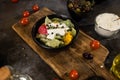 Flat lay composition of bowl of dumplings, jar of sour cream on wooden board