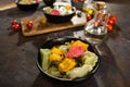 Flat lay composition of bowl of dumplings, jar of sour cream on wooden board