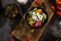 Flat lay composition of bowl of dumplings, jar of sour cream on wooden board