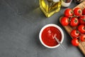 Flat lay composition with bowl of sauce and tomatoes on grey table Royalty Free Stock Photo