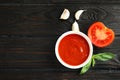Flat lay composition with bowl of tomato sauce on wooden table Royalty Free Stock Photo