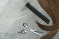 Flat lay composition with brown hair, comb, thinning scissors and space for text. Hairdresser service Royalty Free Stock Photo