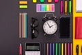 Flat lay composition of business desk with smartphone, glasses, stickers, and colored pens with copyspace on black and Royalty Free Stock Photo
