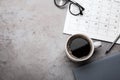 Flat lay composition with calendar and cup of coffee on stone table. Space for text