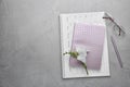 Flat lay composition with calendar, notebook and beautiful flower on grey table. Space for text