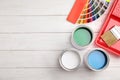 Flat lay composition with cans of paint, brush and renovation tools on wooden background Royalty Free Stock Photo