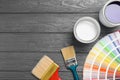 Flat lay composition with cans of paint, brushes and palette on grey wooden background Royalty Free Stock Photo