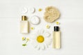 Flat lay composition with chamomiles and cosmetic products on wooden table