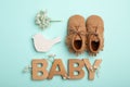 Flat lay composition with child`s booties and word Baby on blue background Royalty Free Stock Photo