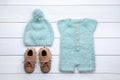 Flat lay composition with child`s clothes and booties on white wooden table Royalty Free Stock Photo