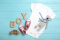 Flat lay composition with child`s clothes, booties and word Boy on blue background Royalty Free Stock Photo