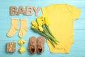 Flat lay composition with child`s clothes and word Baby on blue wooden table Royalty Free Stock Photo