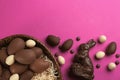 Flat lay composition with chocolate Easter bunny, candies and eggs on pink background. Space for text Royalty Free Stock Photo