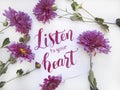 Flat lay composition with chrisanthemums and lettering card `Listen to your heart`