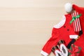 Flat lay composition with Christmas baby outfit on wooden background. Space for text