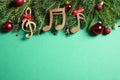 Flat lay composition with Christmas decor and music notes on light green background Royalty Free Stock Photo