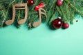 Flat lay composition with Christmas decor and music notes on light green background Royalty Free Stock Photo