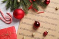 Flat lay composition with Christmas decorations and music sheets on wooden table Royalty Free Stock Photo