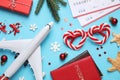 Flat lay composition with Christmas decorations, toy airplane and passports on light blue background. Winter vacation Royalty Free Stock Photo