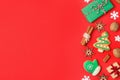 Flat lay composition with Christmas decorations and treats on red background. Winter holidays