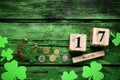 Flat lay composition with clover leaves and block calendar on green wooden table, space for text. St. Patrick`s Day celebration Royalty Free Stock Photo