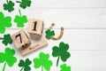 Flat lay composition with clover leaves and block calendar on white wooden table, space for text. St. Patrick`s Day celebration Royalty Free Stock Photo