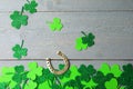 Flat lay composition with clover leaves and horseshoe on grey wooden background. St. Patrick`s day Royalty Free Stock Photo