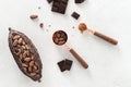 Flat lay composition with cocoa beans, chocolate pieces, cocoa powder and pods on white concrete background. Organic food, natural Royalty Free Stock Photo