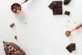 Flat lay composition with cocoa beans, chocolate pieces, cocoa powder and pods on white concrete background. Organic food, natural Royalty Free Stock Photo