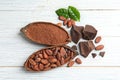 Flat lay composition with cocoa pods and chocolate on wooden table Royalty Free Stock Photo