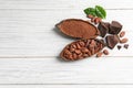 Flat lay composition with cocoa pods and chocolate on white wooden table Royalty Free Stock Photo