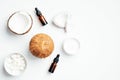 Flat lay composition with coconut essential oil bottles, moisturizing face cream lotion and coconuts on white background. Top view Royalty Free Stock Photo