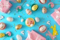 Flat lay composition of color eggs cute rabbits gift boxes sprinkles meringue cake toppers