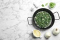 Flat lay composition with cooked spinach and space for text on marble table. Healthy food