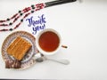 Flat lay composition with cup of black tea, peace of cake and calligraphy lettering of Thank you Royalty Free Stock Photo