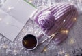 Flat lay composition with cup of hot beverage, knitting yarn and book on fuzzy rug