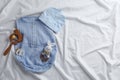 Flat lay composition with cute baby clothes and accessories on bedsheet, space for text