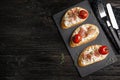 Flat lay composition with delicious bruschettas on black wooden table