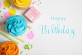 Flat lay composition with cupcakes and text Happy Birthday on white background Royalty Free Stock Photo