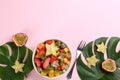 Flat lay composition with delicious exotic fruit salad on pink background. Space for text Royalty Free Stock Photo
