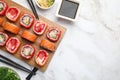 Flat lay composition with delicious sushi rolls on white marble table. Space for text Royalty Free Stock Photo