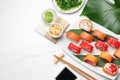 Flat lay composition with delicious sushi rolls on white marble table. Space for text Royalty Free Stock Photo