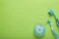 Flat lay composition with dental floss and different teeth care products on green background, space for text Royalty Free Stock Photo