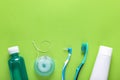 Flat lay composition with dental floss and different teeth care products on green background, space for text Royalty Free Stock Photo