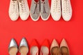 Flat lay composition with different bright shoes on red background