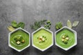 Flat lay composition with different fresh vegetable detox soups made of green peas, broccoli and spinach in dishes on table. Royalty Free Stock Photo