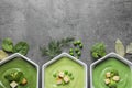Flat lay composition with different fresh vegetable detox soups made of green peas, broccoli and spinach in dishes on table. Royalty Free Stock Photo