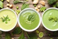 Flat lay composition with different fresh vegetable detox soups made of green peas, broccoli and spinach in dishes